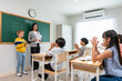 © Kawee - Group of student learn with teacher in classroom at elementary school.