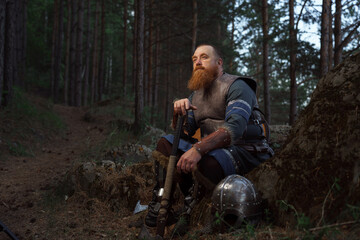 Medieval warrior viking barbarian with ax and shield in forest