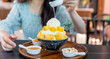 Shaved ice dessert with mango slices. Served with vanilla ice cream and whipped cream. Sweet dessert in Korean style. Local name, Bingsu.