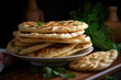 a stack of oriental flatbreads in a plate on a wooden table with greenery, close-up