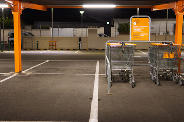 Many rows of orange trolleys outside the store with a close-up of the parking lot, there is a place for an inscription