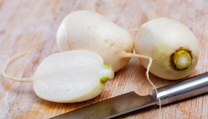 Wall Mural - Whole and cut in half ripe turnips root crops on wooden background. Healthy nutrition concept