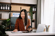 © laddawan - Asian young businesswoman working in the office with working notepad, tablet and laptop documents