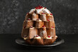 Delicious Pandoro Christmas tree cake with powdered sugar and berries on black table