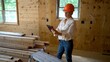 © Robert Peak - Woman architect with hard hat doing walkthrough inspection of new house construction with computer tablet.