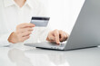 © Fahng - Woman hand holding credit card and using laptop at home, online shopping and paying bills, Payment method.
