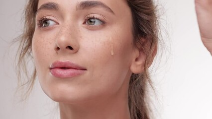 woman with clean skin applying serum to her face. lady applying face serum using pipette for moistur
