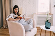 © BullRun - Focused up the spout woman reading magazine at home
