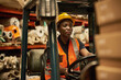 © mavoimages - Young African female forklift operator at work in a textile storehouse