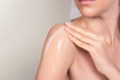 © ADDICTIVE STOCK - Crop anonymous woman applying moisturizing cream on shoulder