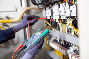electrician engineer tests electrical installations and wires on relay protection system. adjustment