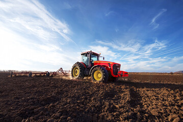 Aufkleber - Tractor cultivating field at spring.