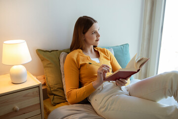 Wall Mural - Young Blonde Lady Reading And Learning With Book At Home