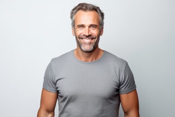 Wall Mural - Portrait of handsome mature man in grey t-shirt on grey background