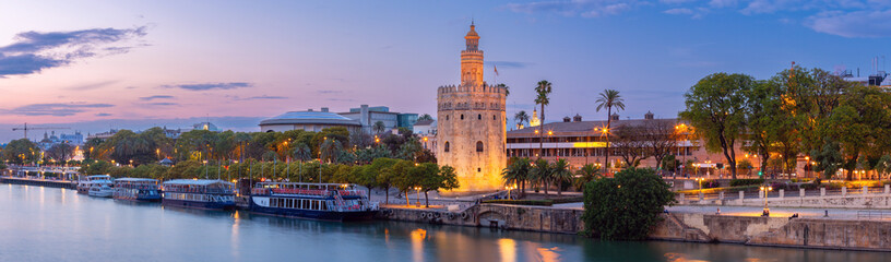 Wall Mural - Sunset panorama over Seville, Guadalquivir river and golden tower Torre del Oro.