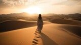 silhouette of beautiful arabic woman walking on the sand dunes in desert in the unset