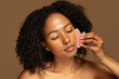 © Prostock-studio - Joyful pretty african woman using gua sha stone, massaging face