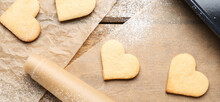 Heart Shaped Cookies And Baking Paper On Wooden Background, Top View