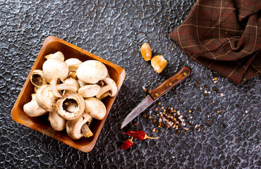 Canvas Print - Raw mushrooms champignons on black background, cooking fresh champignons