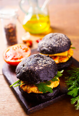 Canvas Print - Tasty craft burger with black bun on the board