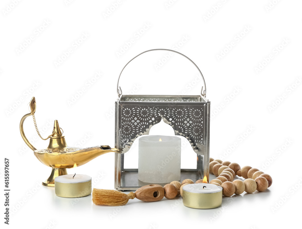 Muslim lantern with Aladdin lamp, burning candles and prayer beads on white background