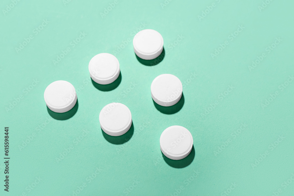 White pills on green background
