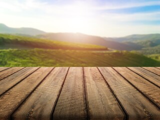 Poster - Wooden empty table top on green field background