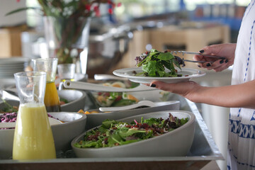 Woman taking food from a buffet line