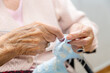 © herraez - Elderly woman crocheting in a handicraft course as a hobby or occupational therapy at nursing home. High quality photo