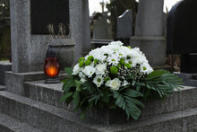 Funeral Wreath Of Flowers And Grave Lantern On Granite Tombstone In Cemetery