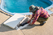 Technician Trying To Fix Swimming Pool Pumps. The Pump Keeps The Water Moving And Prevents Stagnation While The Filter Removes Debris And Contaminants.