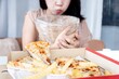 Asian Woman Vomiting and Indigestion Due to Overeating Pizza, bulimia, binge eating concept