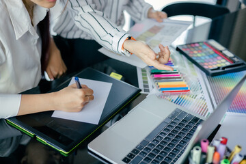 graphic designer working with laptop and color swatch. creative man using digital tablet at modern office.