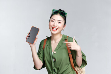 Young woman showing smartphone for presenting and pointing something on a travel summer trip