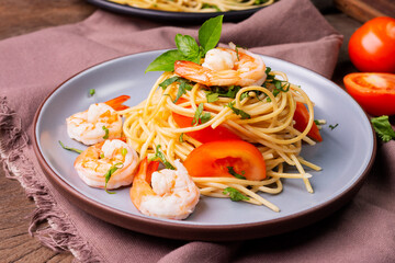 Poster - Stir-fried spaghetti or stir-fried noodles Tomato sauce and prawns on a plate and tomato basil on wooden table background, top view