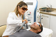 © Franci Leoncio - Happy woman beautician treating patient with laser
