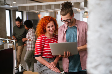 Diverse group of professionals meeting in office. IT programmers use computer, talk strategy