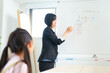 © maru54 - 子どもに向かって授業するスーツ姿の女性