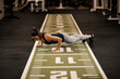 © Dusan Petkovic - A strong female bodybuilder is doing pushups in a gym.