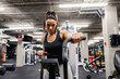© Dusan Petkovic - A dedicated sportswoman is doing exercises on a elliptical machine in a gym.