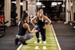 © dusanpetkovic1 - Female coach is helping a sportswoman with lunges exercises in a gym.
