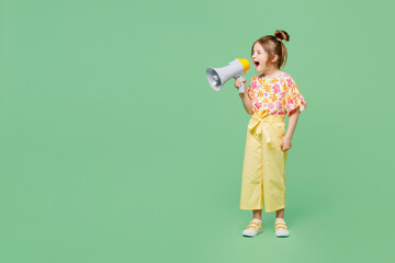 Full body little child kid girl 6-7 year old wear casual clothes hold in hand megaphone scream announce discounts sale isolated on plain green background. Mother's Day love family lifestyle concept.