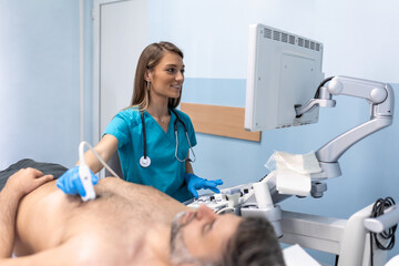 Doctor performs chest ultrasound on man in hospital room. Examination of the heart and vessels concept