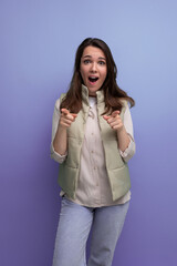 Wall Mural - shocked brunette young lady in casual outfit on studio background