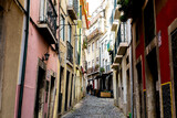 Fototapeta Uliczki - Two young women walk up a narrow street in Lisbon