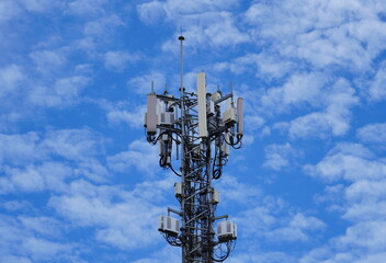 Wall Mural - Telecommunication tower of 4G and 5G cellular. Macro Base Station. 5G radio network telecommunication equipment with radio modules and smart antennas mounted on a metal against cloulds sky background.