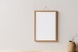 © ParinApril - Blank Wooden Picture Frame Mockup Hanging on Beige Wall Empty Poster Mockup for Art Display. Front View with Copy Space, Generative AI