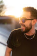 © Sergio Amate - Portrait of a young man with glasses: A sunlit day frames the confident gaze of a stylish young man, capturing his youthful charm.