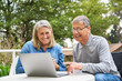 © Robert Kneschke - Happy senior couple discussing over laptop in garden