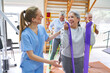 © Robert Kneschke - Therapist assisting elderly woman doing workout at rehab center